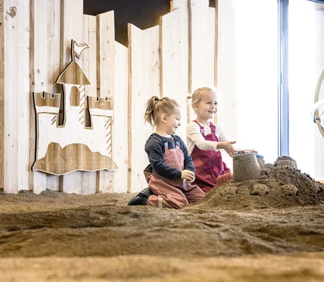 Zwei kleine Kinder bauen eine Sandburg im Familienhotel Familotel Allgäuer Berghof