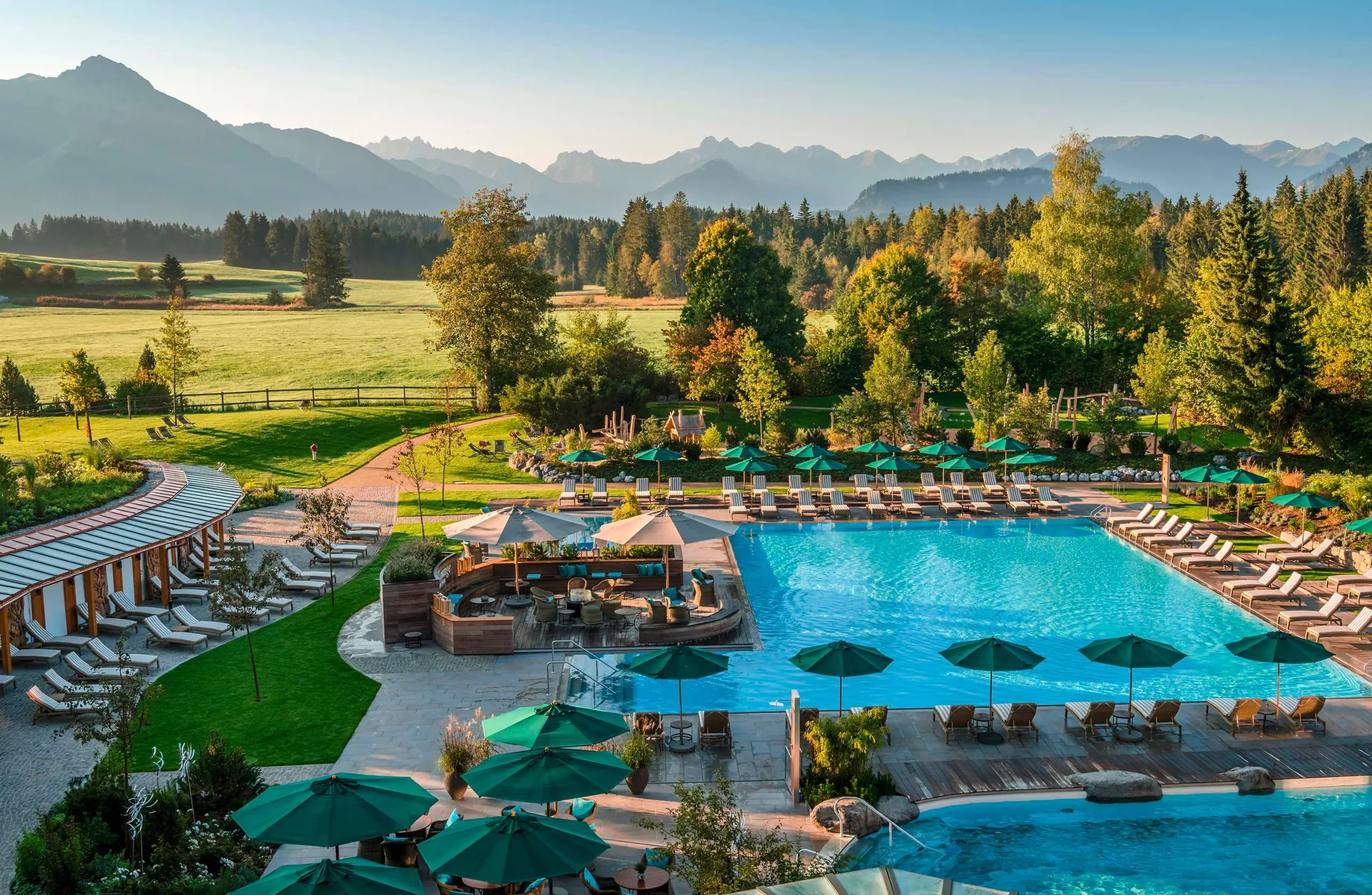 Blick über den Außenpool mit vielen Liegen im Familienhotel Sonnenalp Resort
