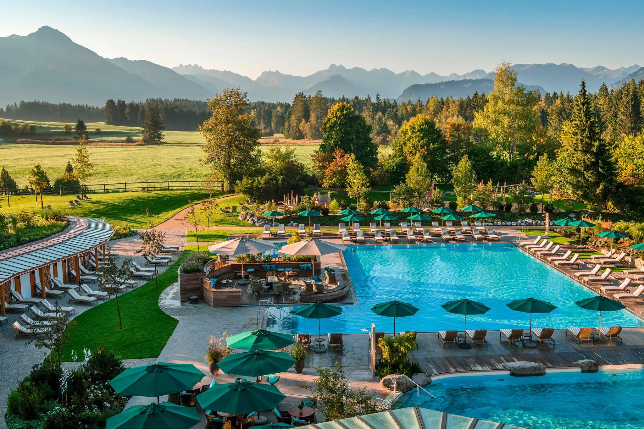 Blick über den Außenpool mit vielen Liegen im Familienhotel Sonnenalp Resort
