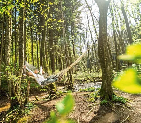 Frau hängt in Hängematte im Wald