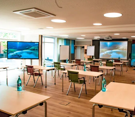 Tagungsraum mit drei Bildschirmen