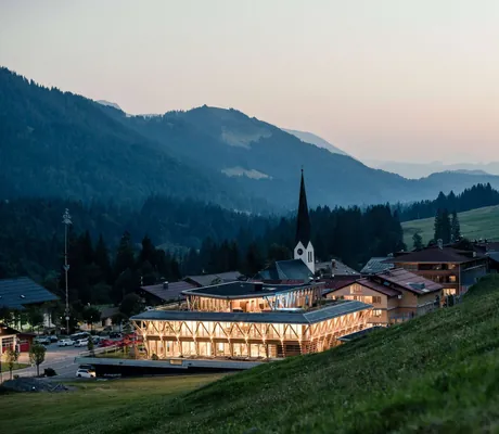 Außenansicht auf das Hundehotel HUBERTUS Mountain Refugio Allgäu und Balderschwang in der abendlichen Dämmerung