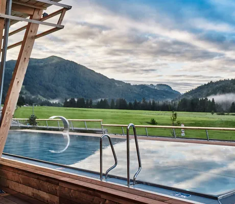Außenansicht auf das sommerliche HUBERTUS Mountain Refugio Allgäu