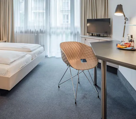 Doppelzimmer mit Schreibtisch in hellem Holz