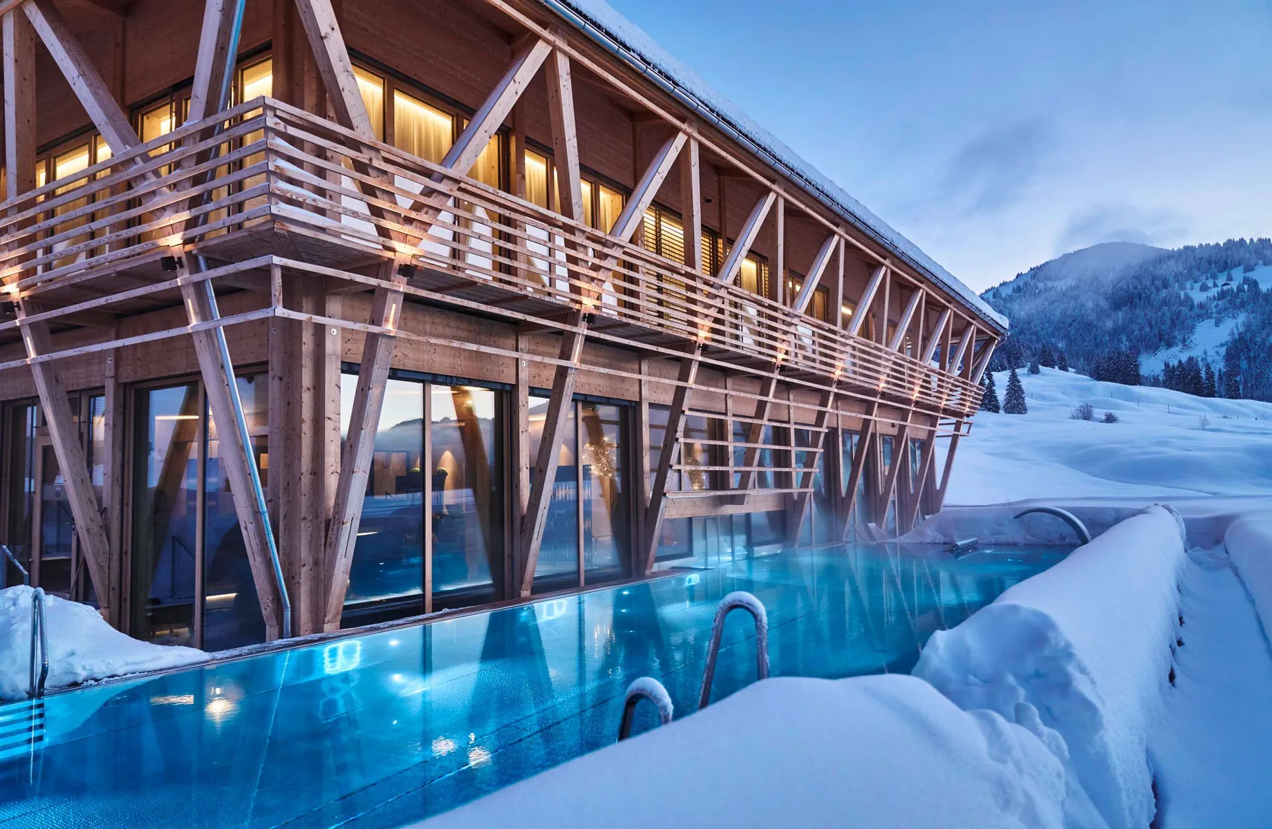 Außenansicht auf das Wellnesshotel HUBERTUS Mountain Refugio Allgäu in winterlichen Verkleidung