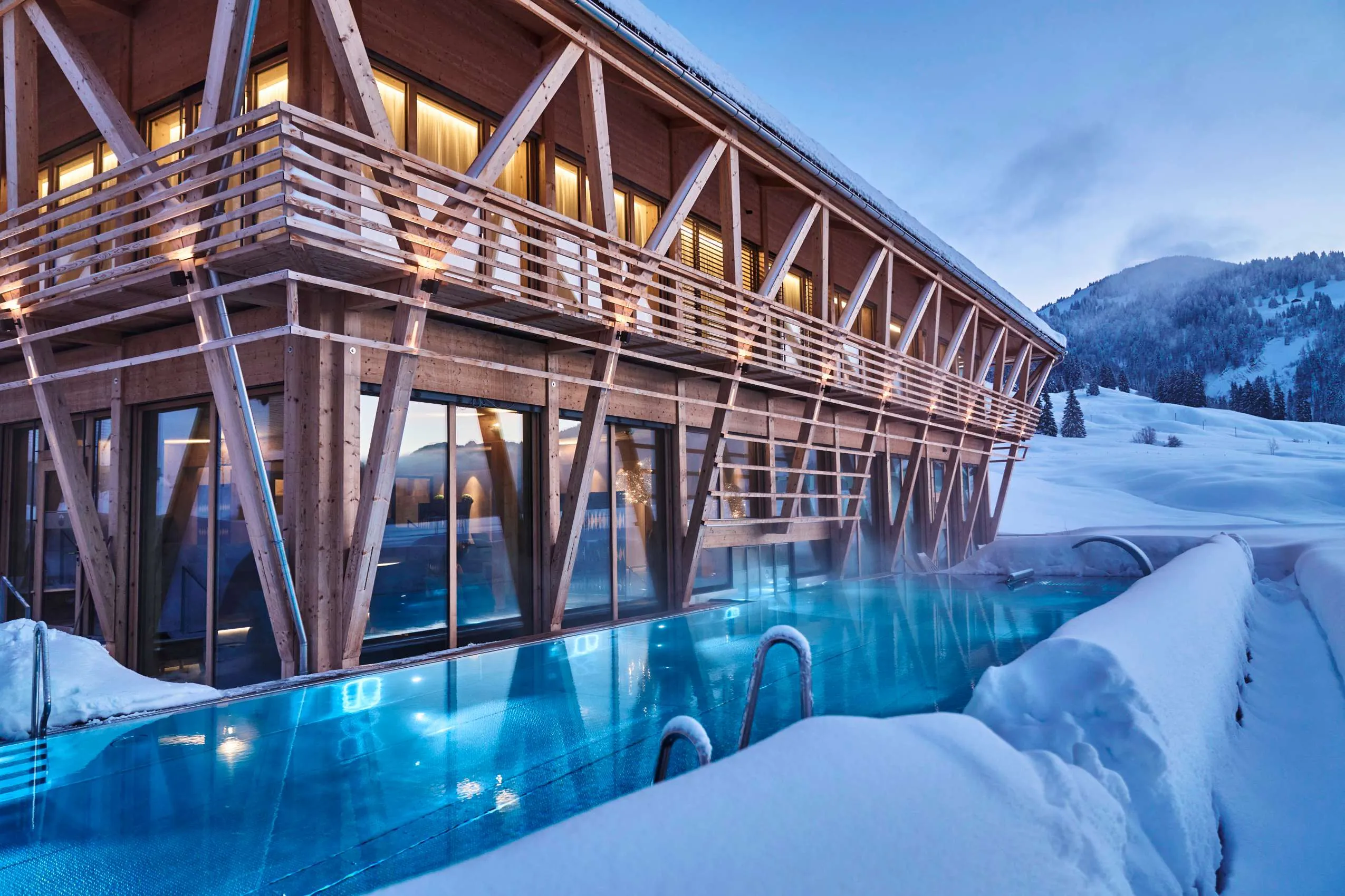 Außenansicht auf das Wellnesshotel HUBERTUS Mountain Refugio Allgäu in winterlichen Verkleidung