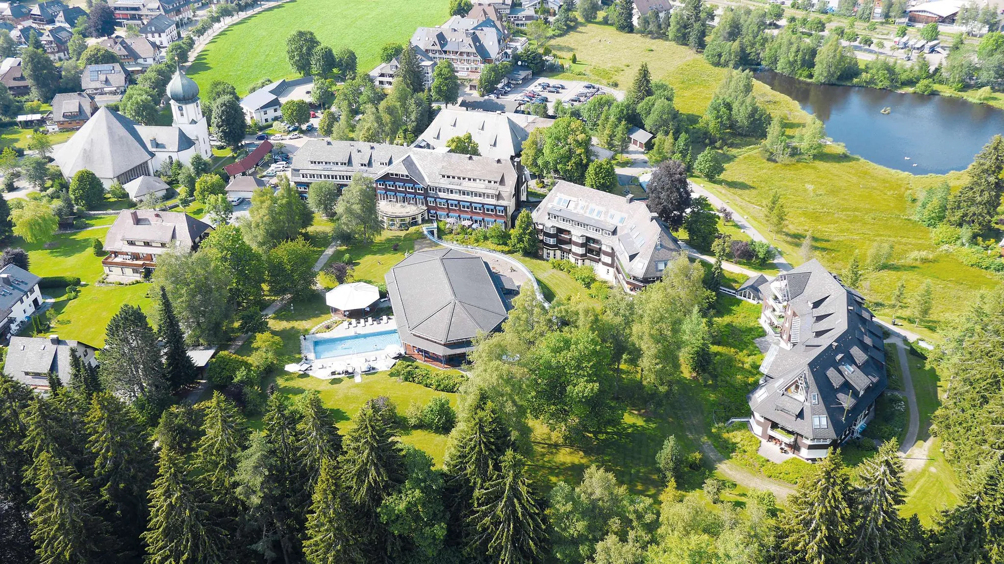 Außenaufnahme mit Outdoorpool und Titisee im Parkhotel Adler
