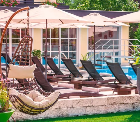 Liegen und weiße Sonnenschirme am Außenpool