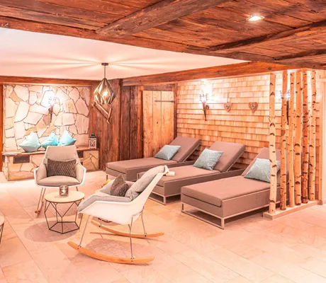 Schaukelstühel und Liegen mit Birkenstämmen im Ruheraum