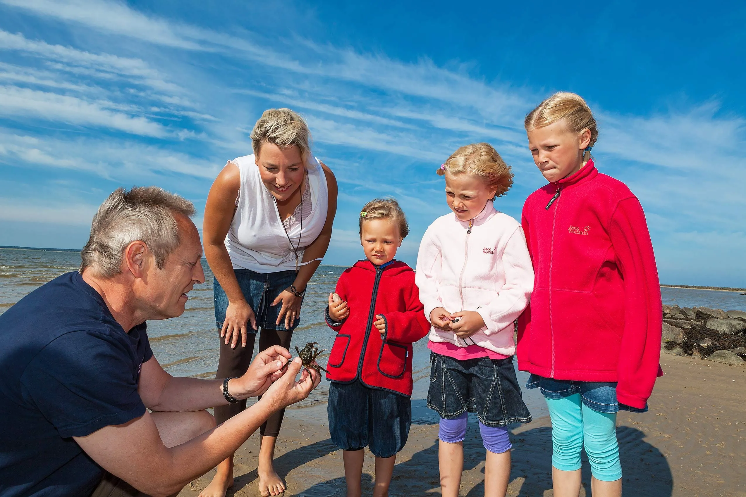 Famiien am Meer betrachtet Krebs