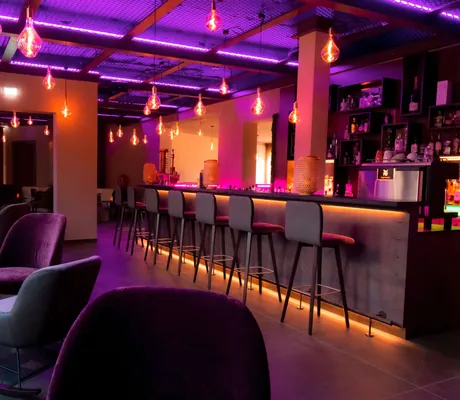 Die Bar des Sporthotel Bornmühle mit Barhockern vor der Theke