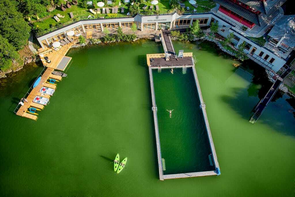 Blick von oben auf den beheizten Hotelpool im Bergsee
