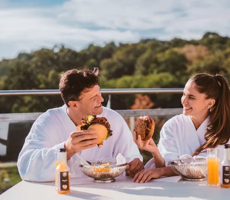 Zwei Personen essen draußen Burger