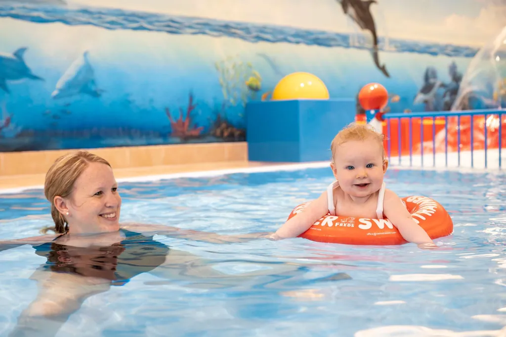 Baby mit Schiwmmreifen badet