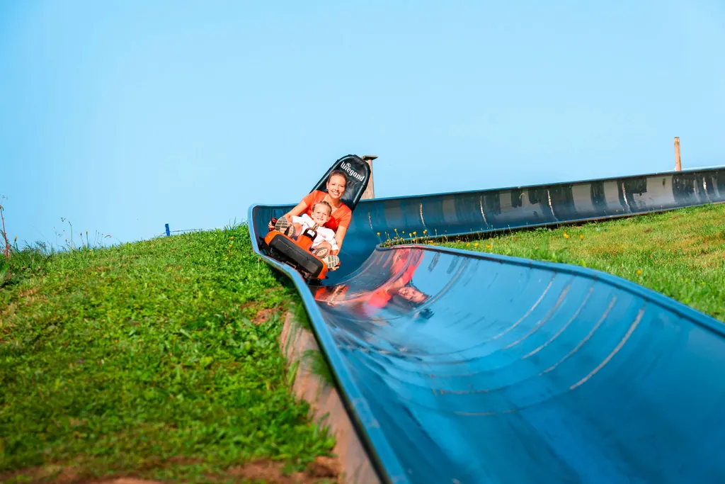 Mutter und Kind fahren in der Sommerrodelbahn