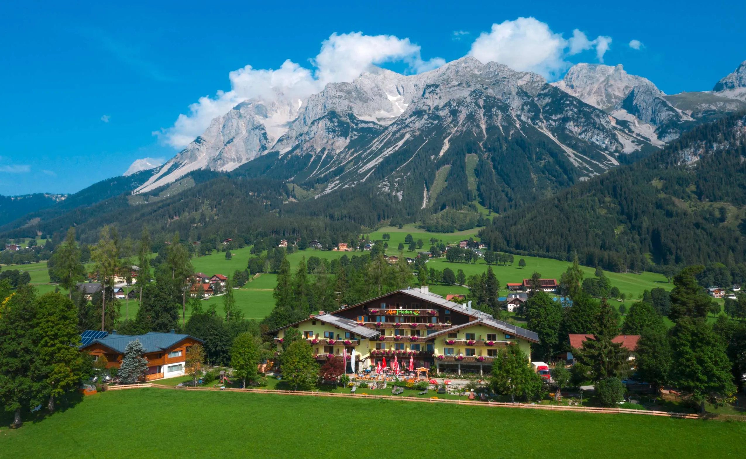 Hotel Almfrieden von oben am Fu&szlig;e eines Berges liegend