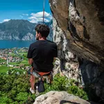 Kletterer hängt mit Blick über den Gardasee.