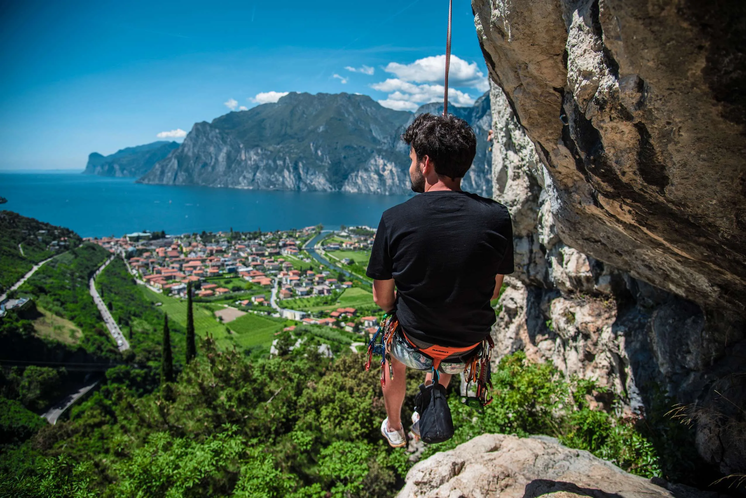 Kletterer hängt mit Blick über den Gardasee.