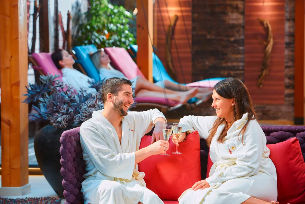 Panorama-Wellnessbereich im Hotel Sommer mit P&auml;rchen, auf dem Sofa sitzend.