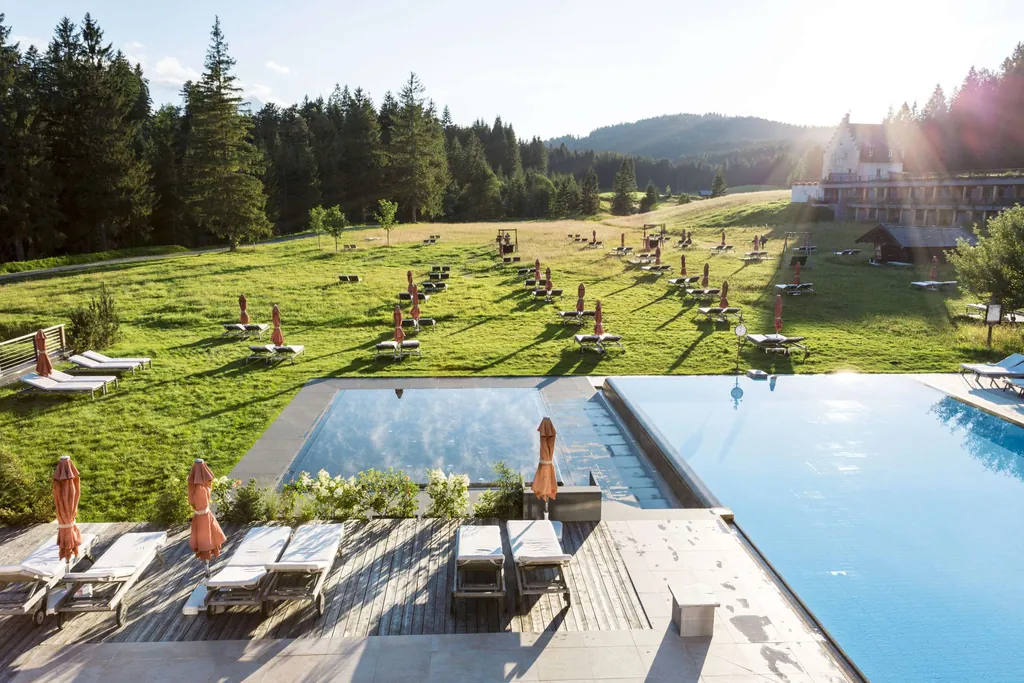 Liegewiese und Poollandschaft vor dem Schloss Kranzbach.