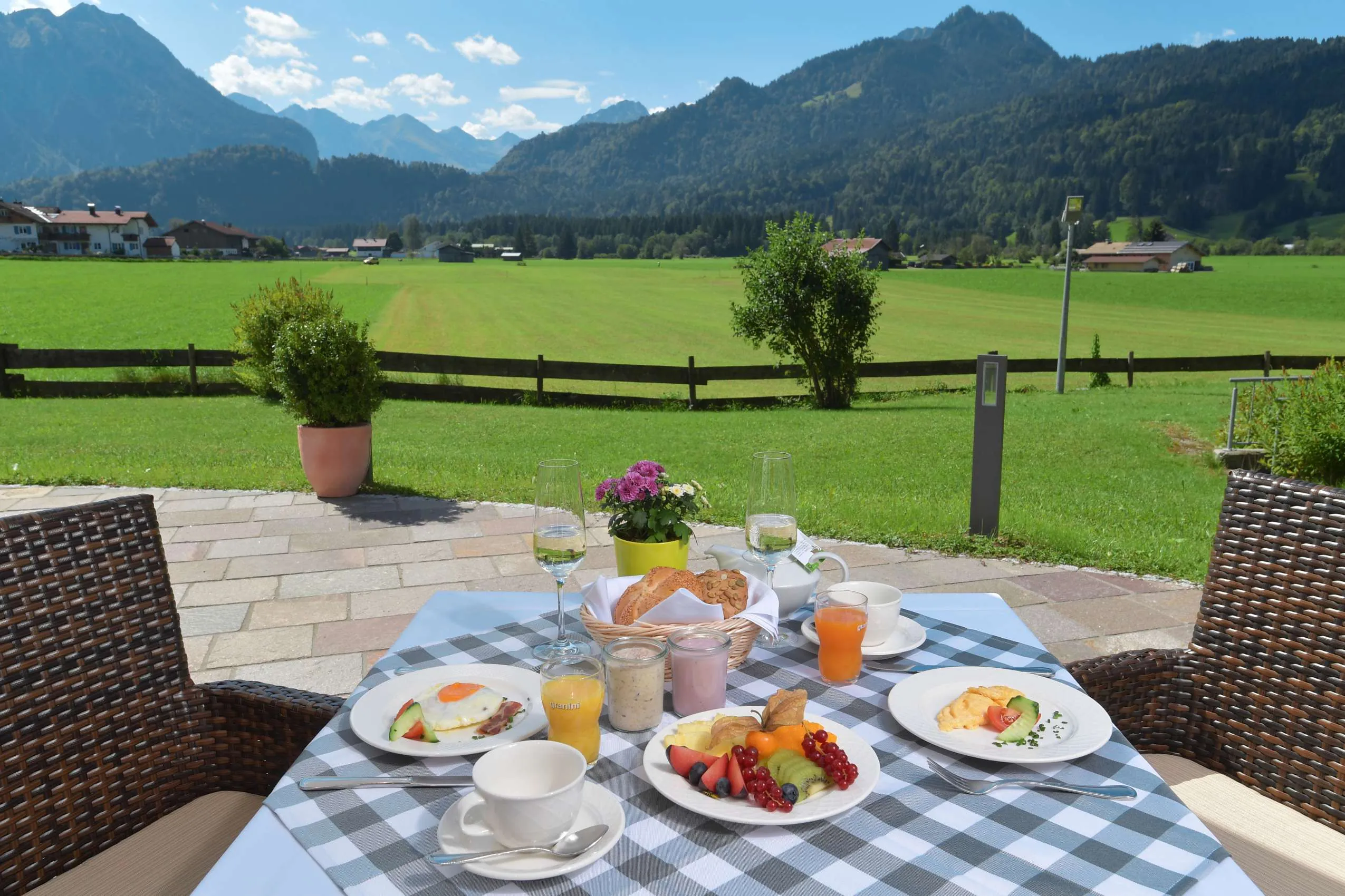 Gedeckter Fr&uuml;hst&uuml;ckstisch vor Alpenpanorama