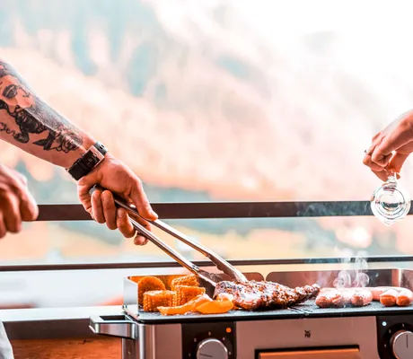 zwei_Hände_am_Grill_Chalet_Salena