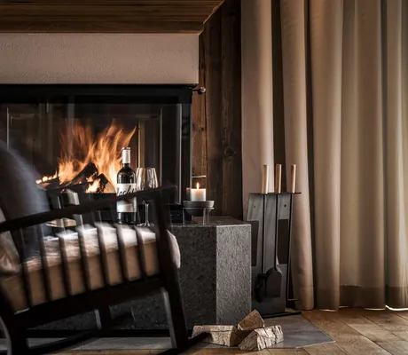 Schaukelstuhl_vor_prasselndem_Kamin_Farm_Resort