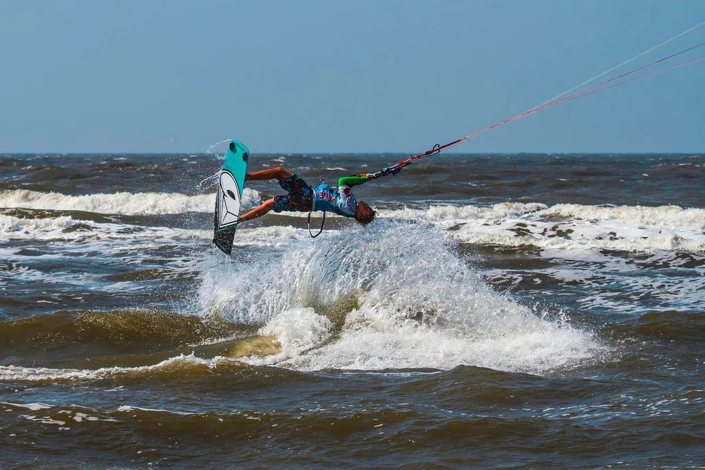 Kytesurfen ist eine beliebte Aktivität für einen Strandurlaub im Deutschland. Das Bild zeigt einen Kytesurfer im Backflip-