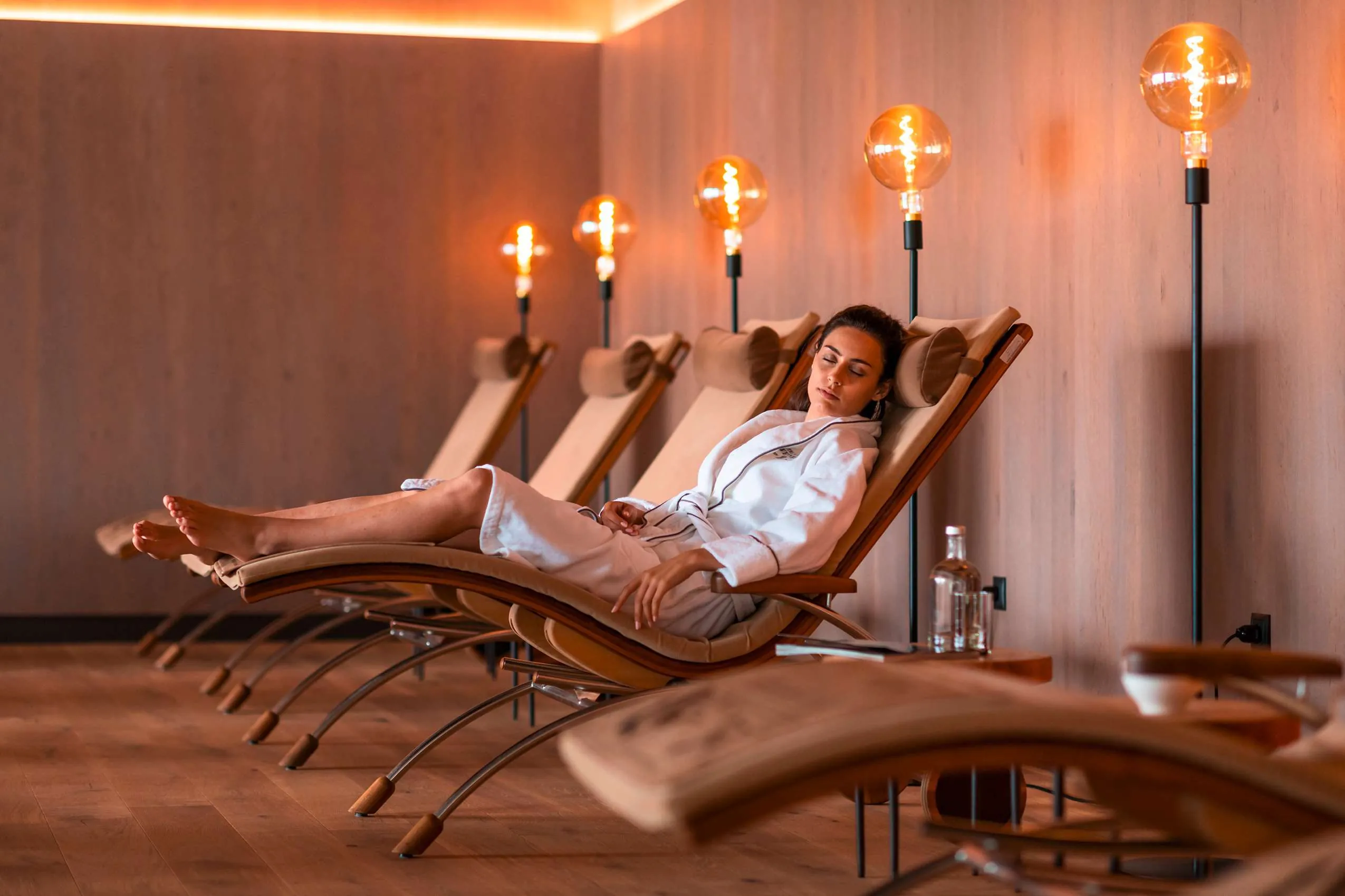 Frau_im_Bademantel_auf_Liege_Wellnesshotels_Suedtirol