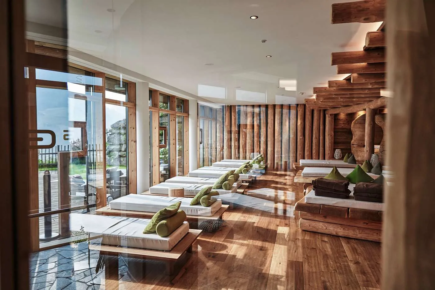 Ruheraum mit Liegen und gro&szlig;en Glasfronten im Wellnesshotel Das.Goldberg
