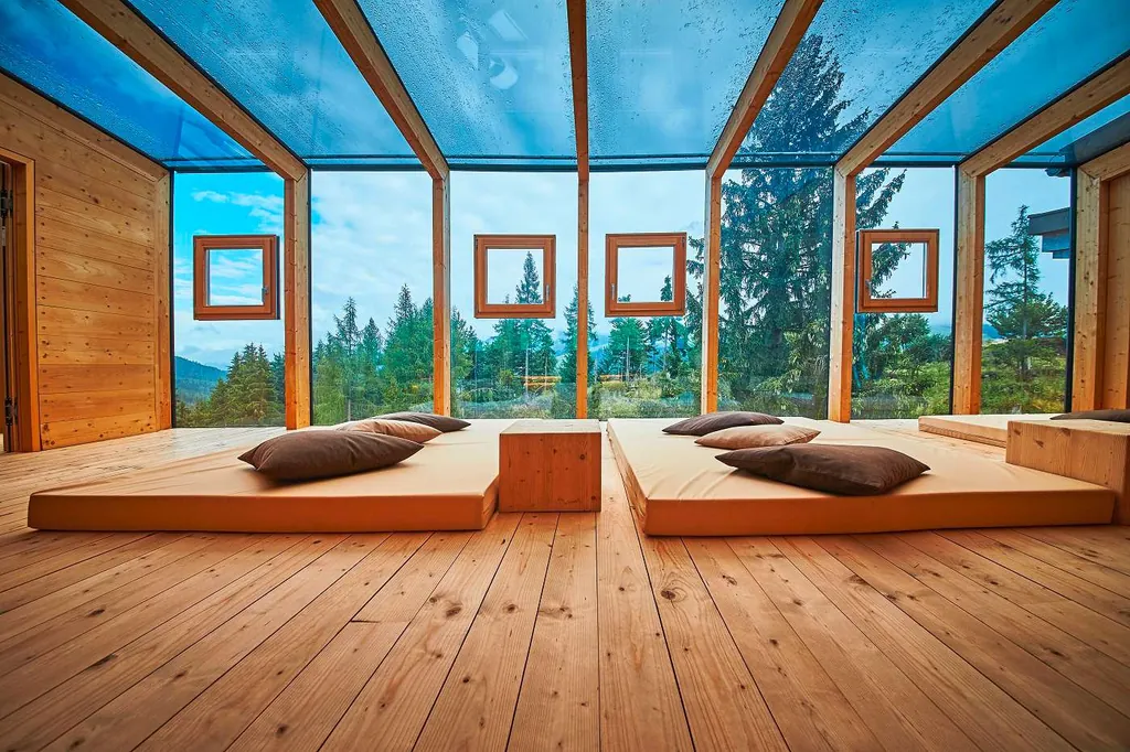 Ruheraum im Holzhotel Forsthofalm mit großen Glasfronten