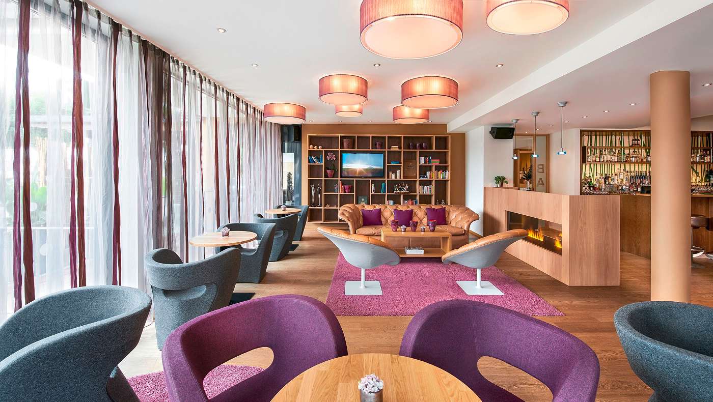 Gemütliche Loung mit farbigen Sesseln und Bar im Wellnesshotel Ritzenhof