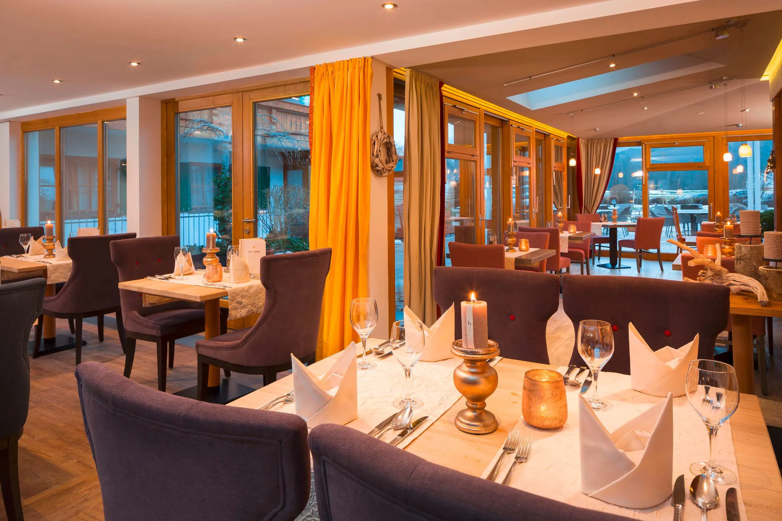 Eingedeckte Tische im Wintergarten des Hotel Sommer