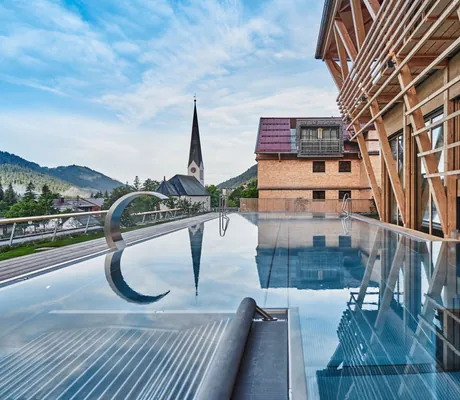 Blick auf den Infinity-Pool des Hubertus Mountain Refugio Allgäu