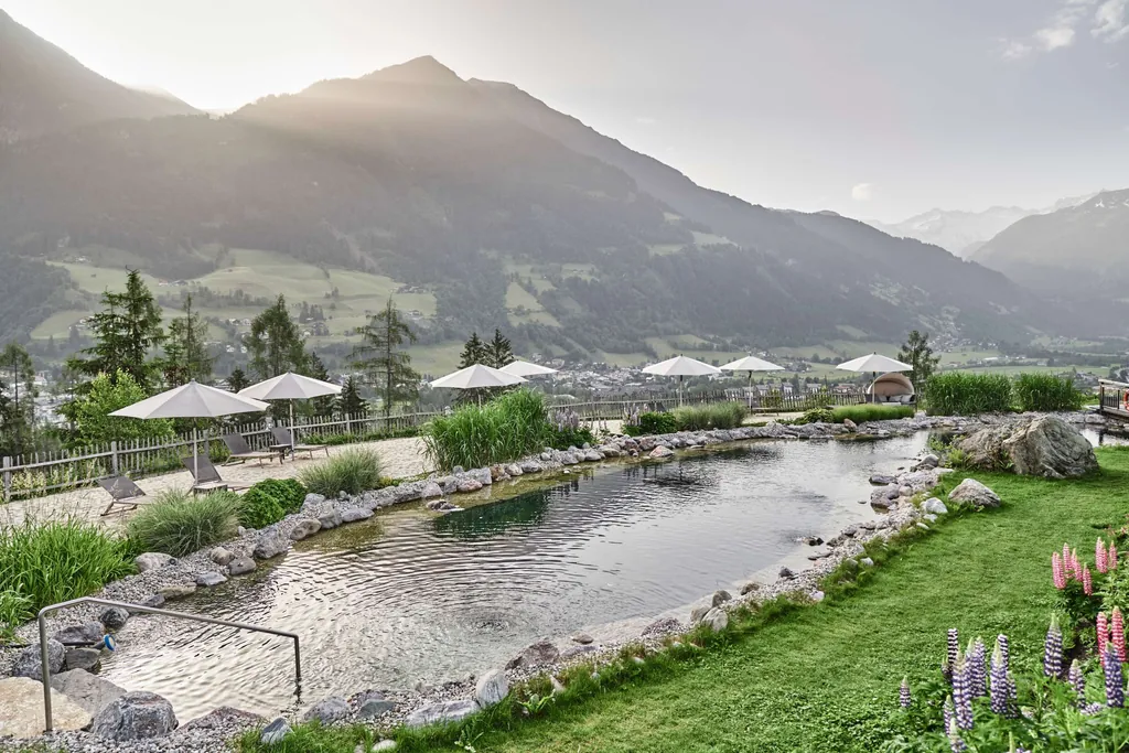 Naturbadeteich mit Sandstrand und Liegen im Wellnesshotel Das.Goldberg
