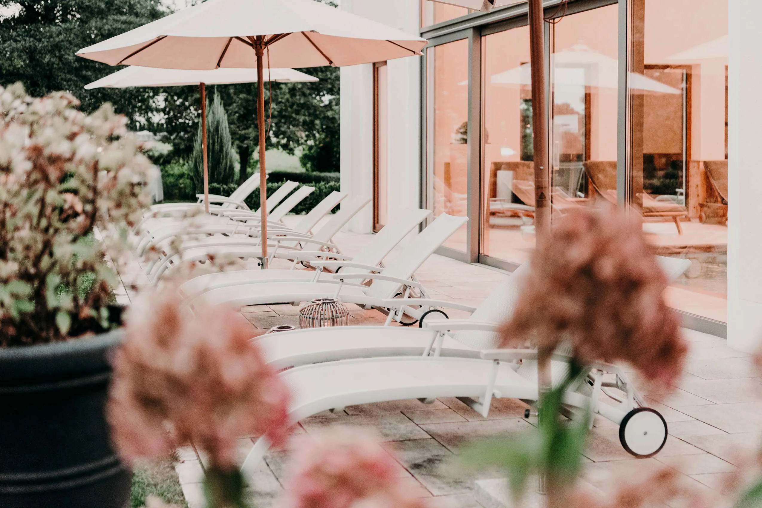 Terasse mit Liegest&uuml;hlen und Sonnenschirmen im Wellnesshoterl der Eisvogel.