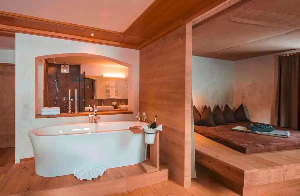 Zimmer mit Badewanne und Bett f&uuml;r den Wellnessurlaub im Rooftophotel FORSTHOFALM