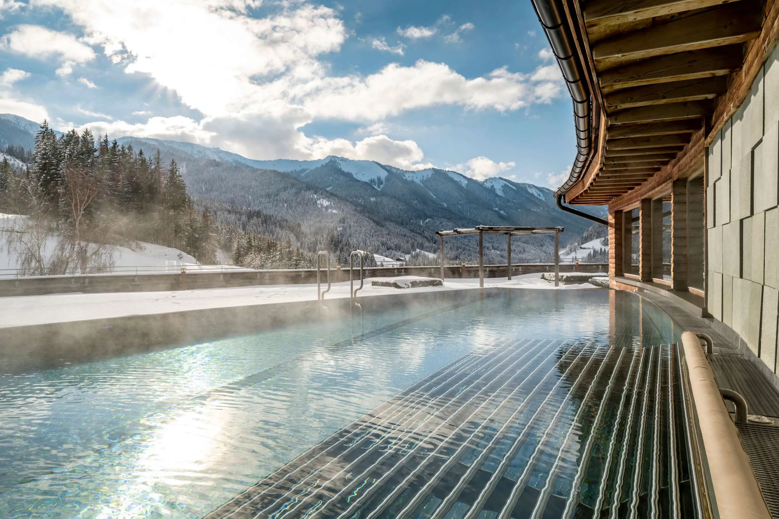 Outdoorpool mit Blick auf die umliegenden Berge im Rooftophotel Forsthofalm.