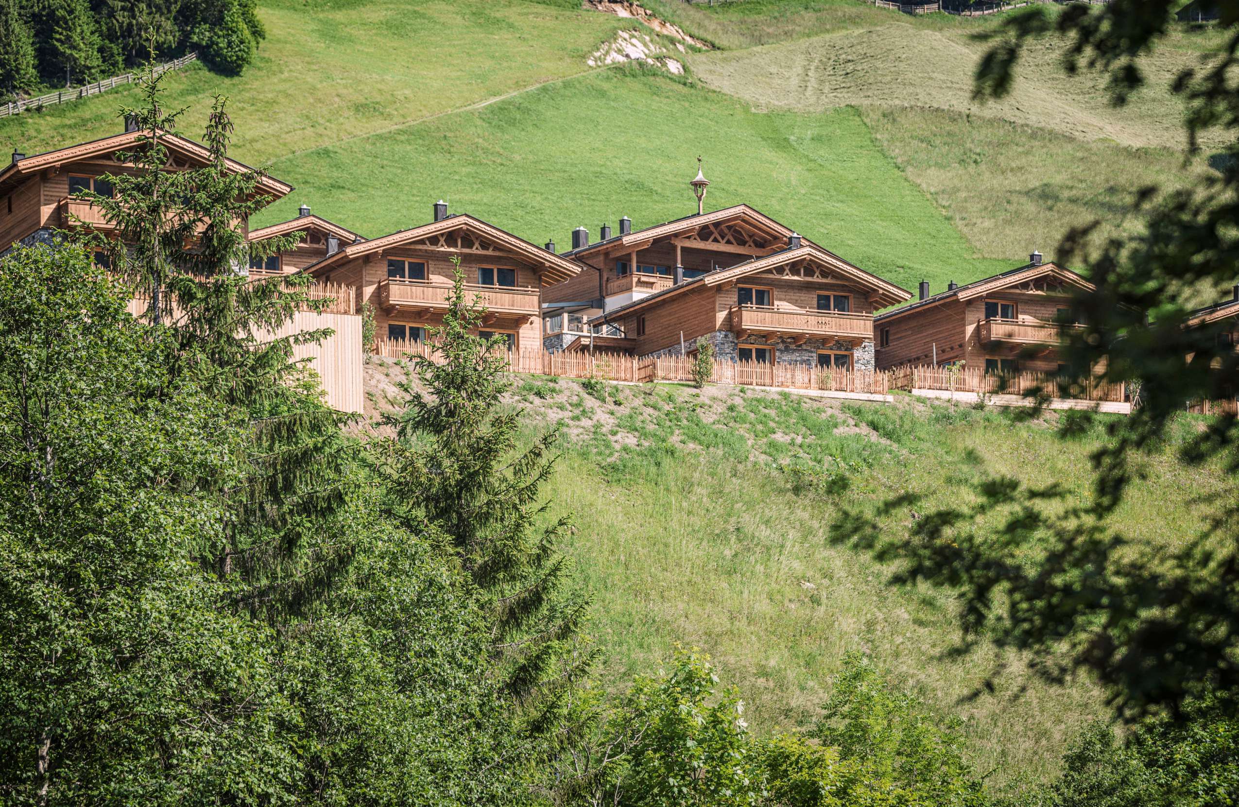 Blick auf die Chalets mitten in den Bergen_FarmResortGeislerhof