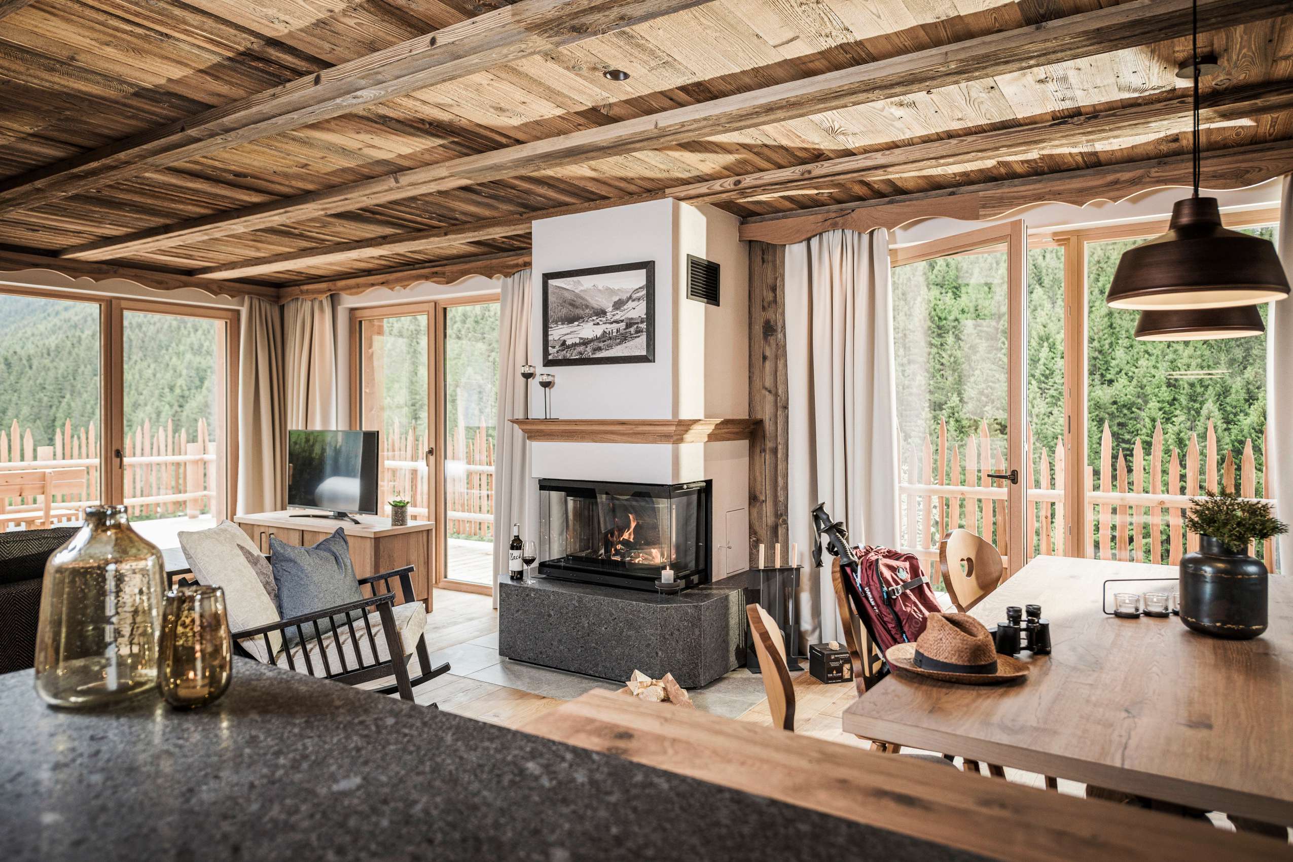 Wohnbereich mit Kamin und Esstisch im Chalet_FarmResortGeislerhof