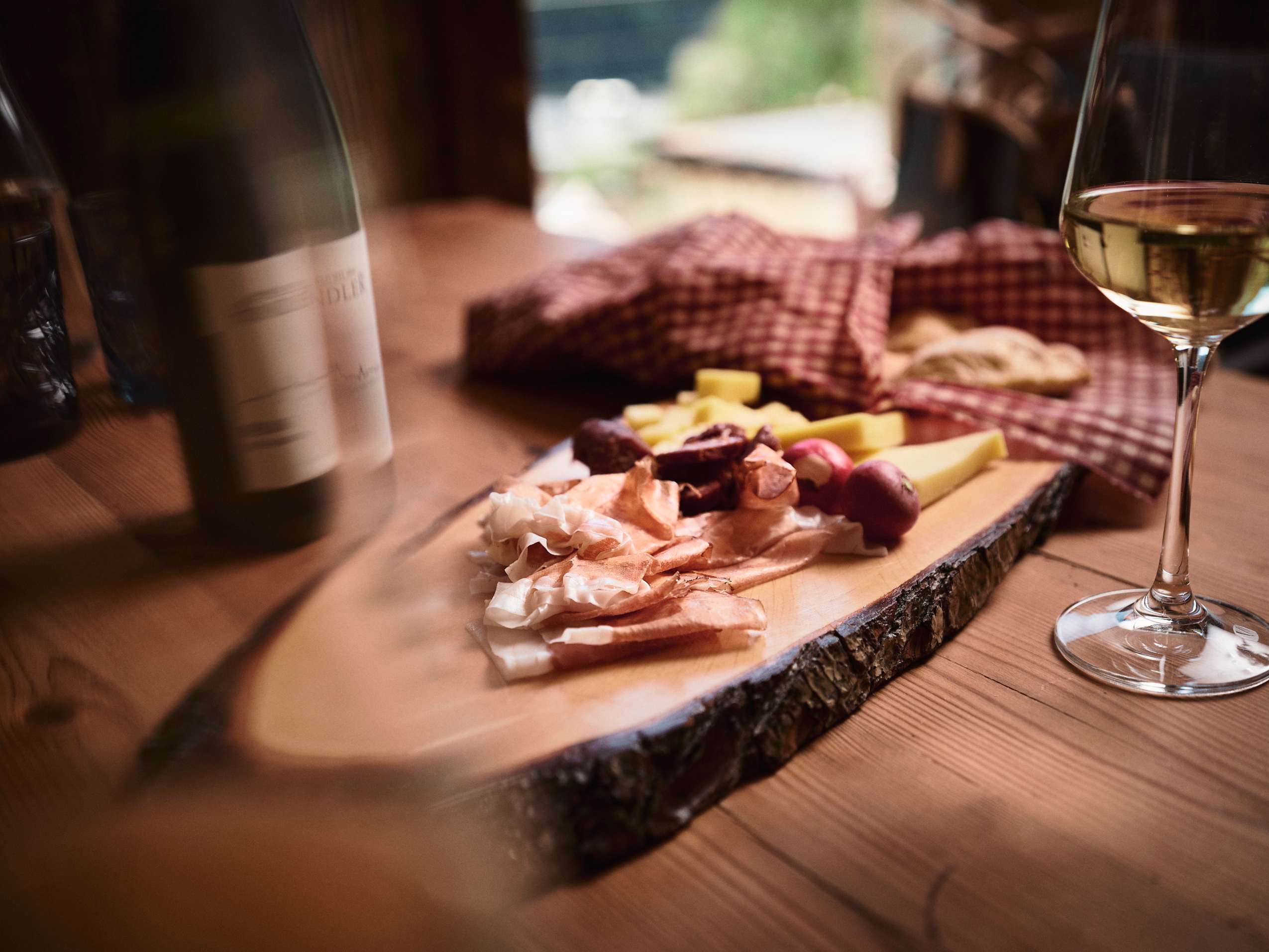 Platte mit Schinken und Käse und einem Glas Wein_Sonnenhang