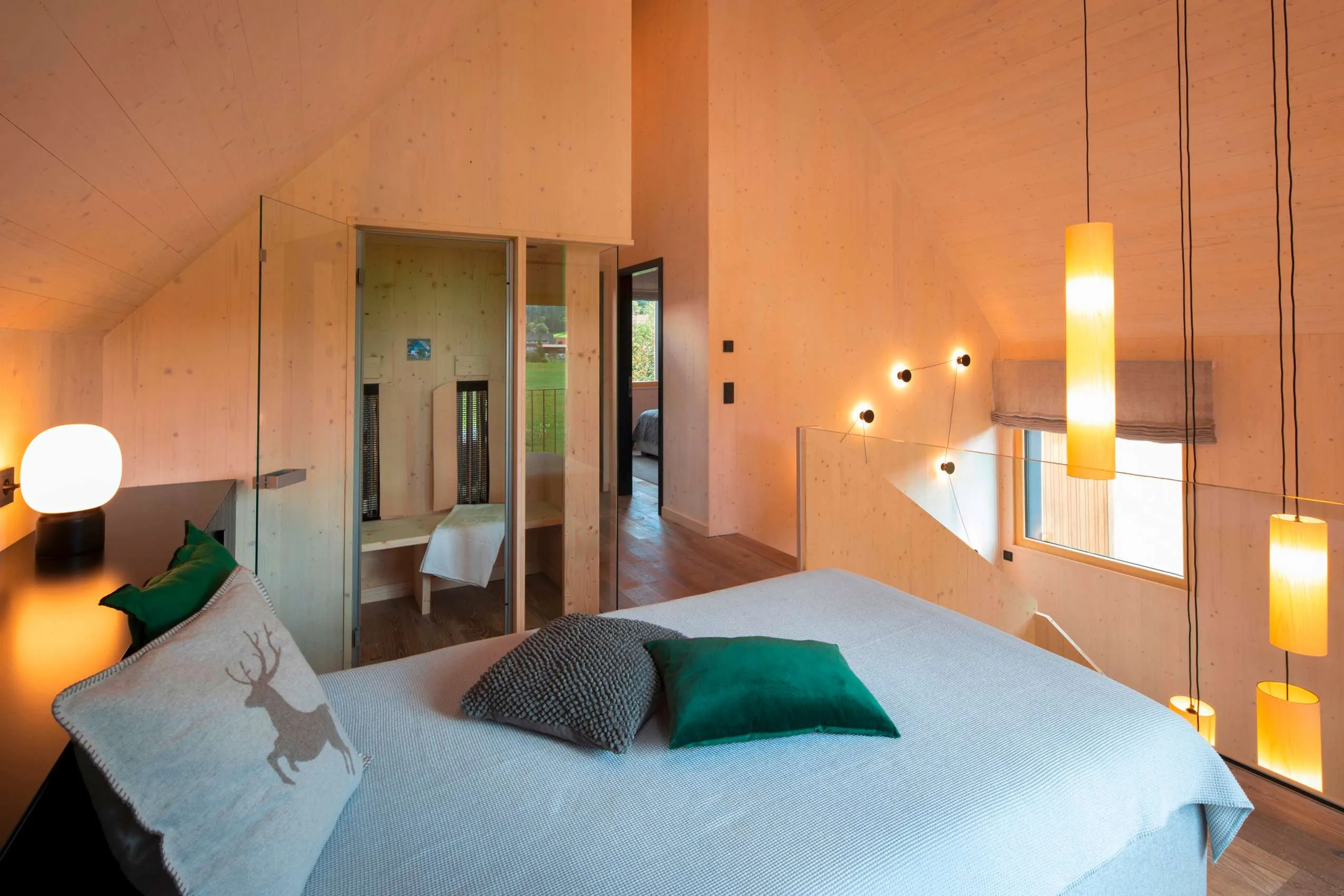 Bett mit gr&uuml;nen Kissen und Lampen im Wellnesshotel Engel Obertal im Schwarzwald