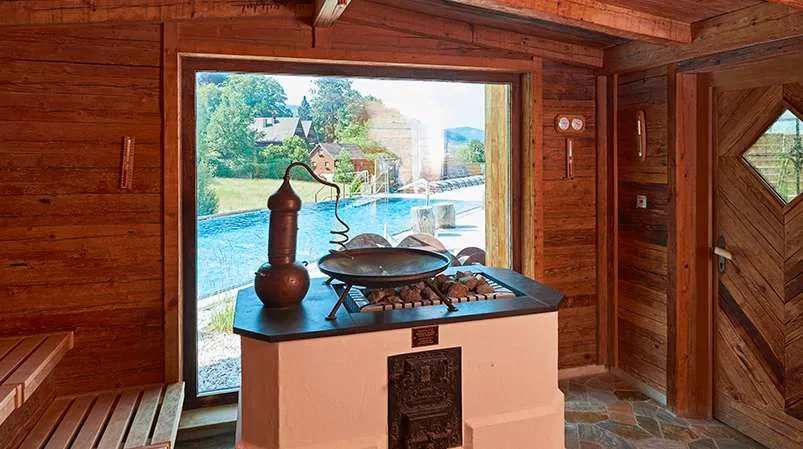 Sauna mit Blick auf den Outdoor-Pool im Wellnesshotel Heselbacher Hof