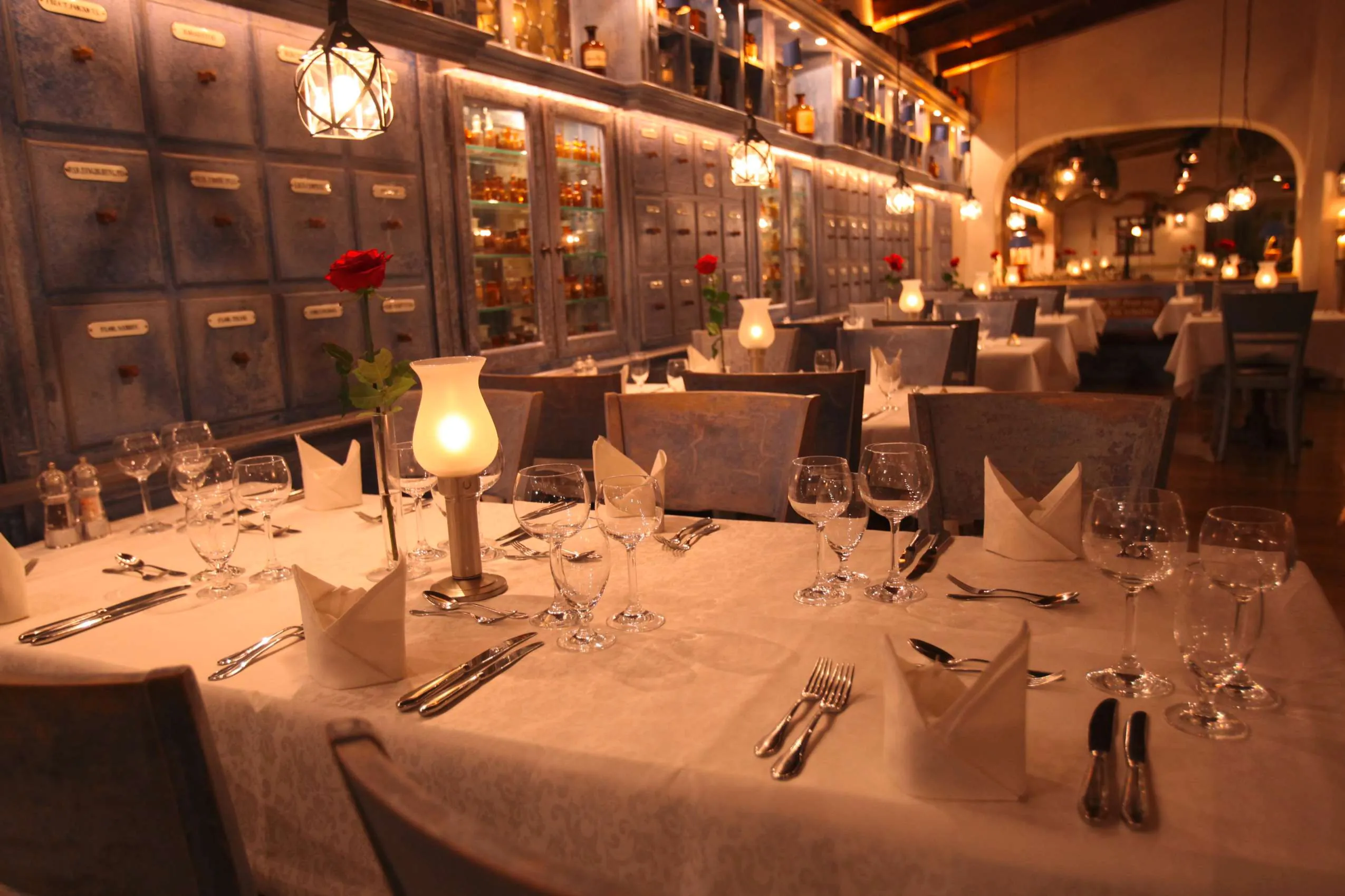 Eingedeckte Tische neben historischer Apothekerwand im Restaurant des Wellnesshotels Santa Isabel