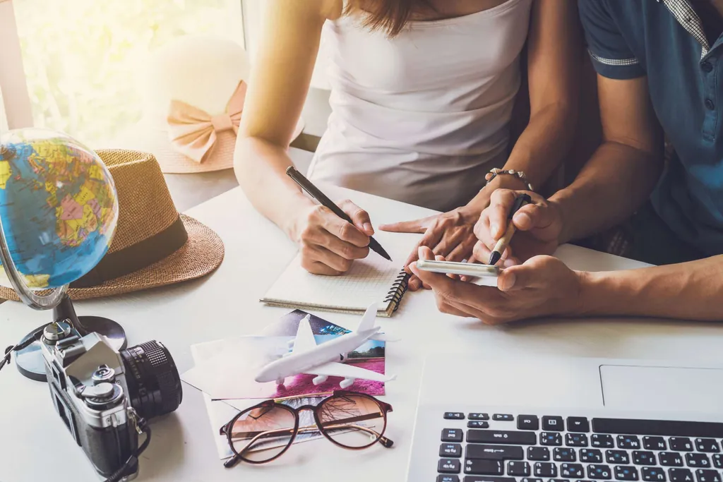 Junges Paar erstellt eine Checkliste für den Urlaub