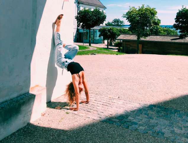 Frau, die sich an Wand dehnt