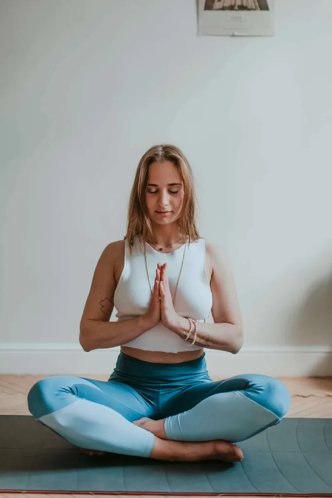 Junge Frau im Schneidersitz macht Yoga