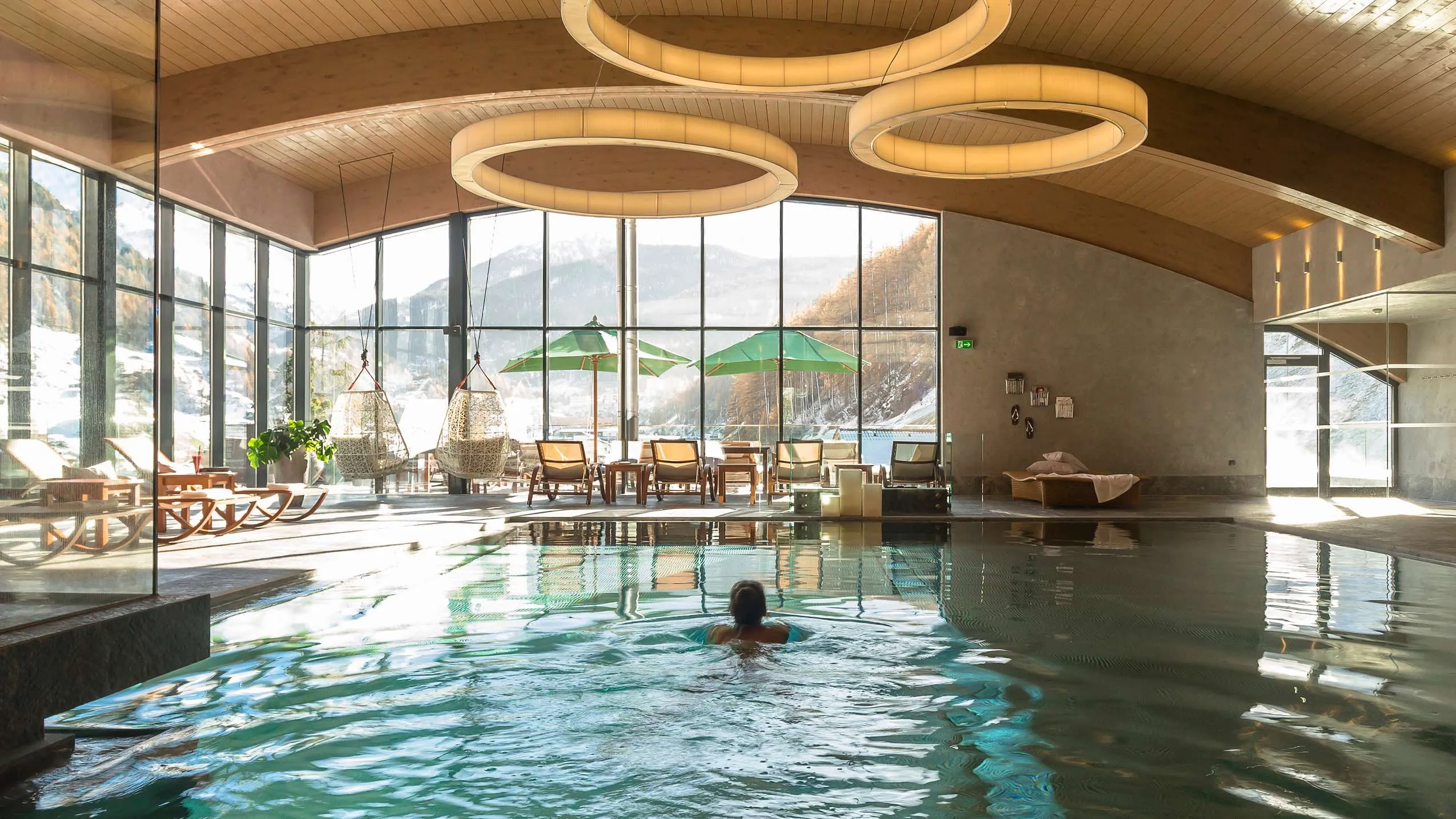 Indoorpool mit runden H&auml;ngeleuchten im Bergland Design- und Wellnesshotel in Tirol