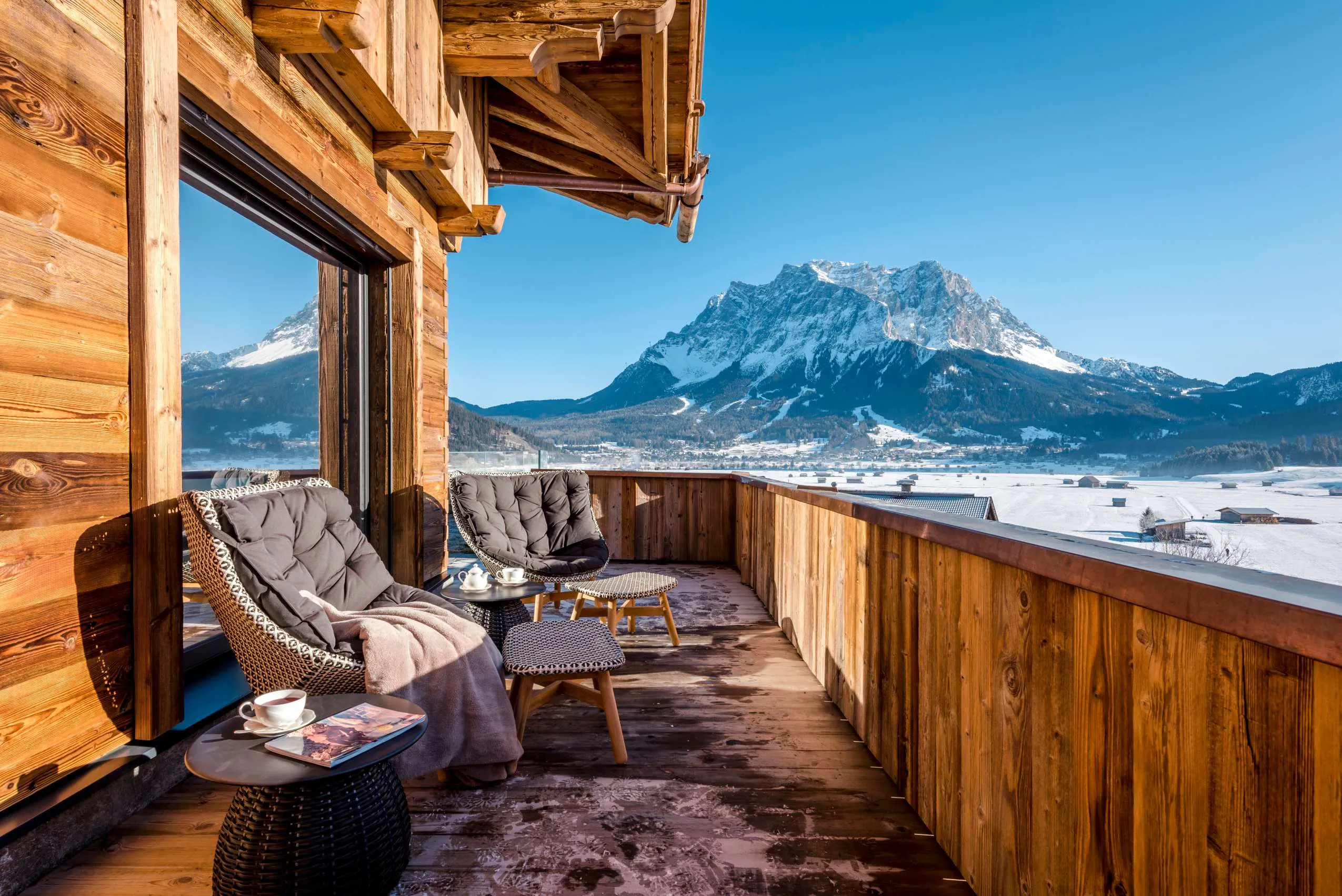 Balkon mit Korbm&ouml;beln im Alpine Luxury Hotel Post Lermoos in Tirol mit Blick auf Berge