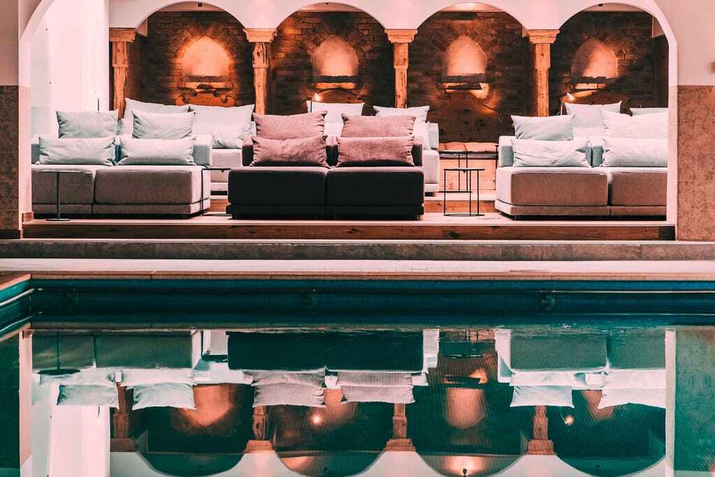 Indoorpool mit Liegen vor dem Klostergewölbe